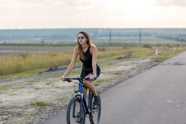 Chica en una bicicleta de montaña en offroad hermoso retrato de un ciclista