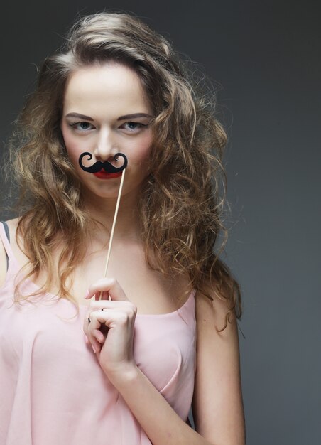 Chica con bigotes falsos.