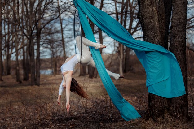 Chica de blanco sobre un aro en el bosque