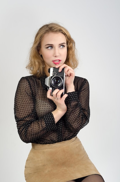 Chica en una blusa negra con una cámara.