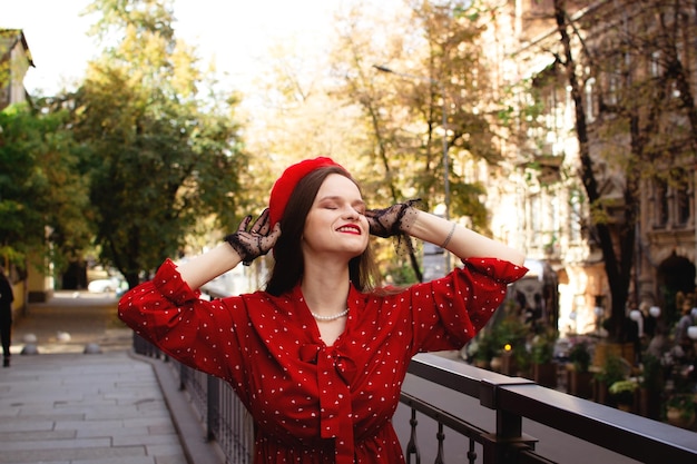 Una chica con una boina roja camina en la ciudad de otoño.