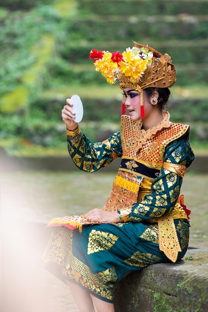 Chica boliviana con traje tradicional se mira en el espejo. bali Indonesia