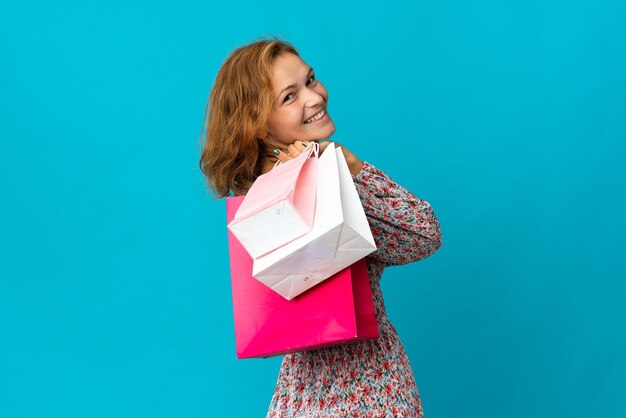 Chica con bolsas de la compra sobre fondo aislado