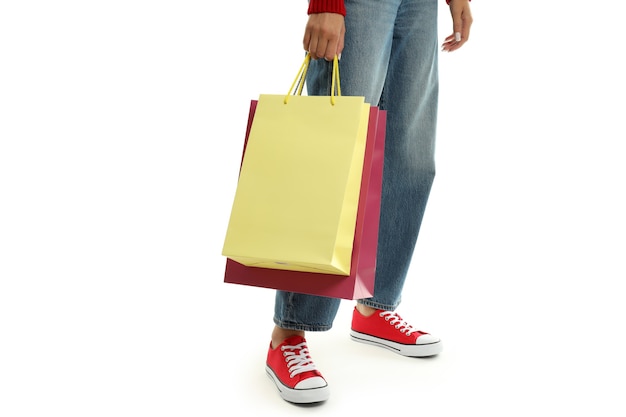 Chica con bolsas de papel multicolores aislado sobre fondo blanco.