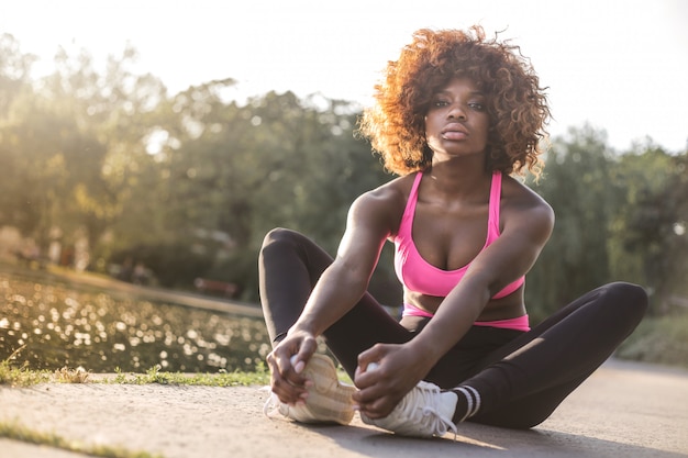 Chica bonita afro en un traje de deporte