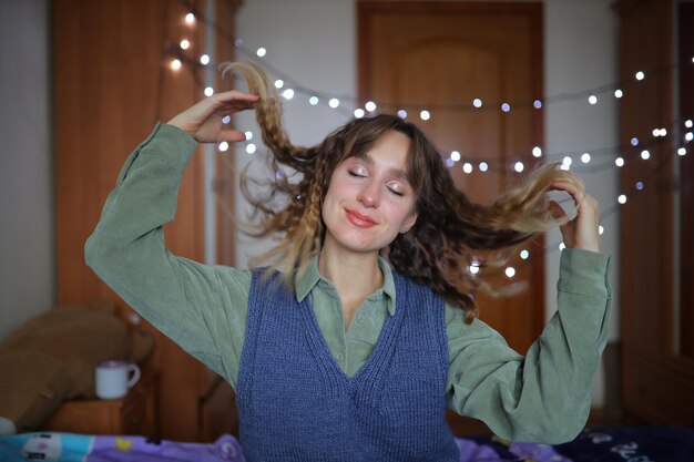 La chica bonita se alisa el pelo La chica tirará el pelo a los lados Chica en un bokeh