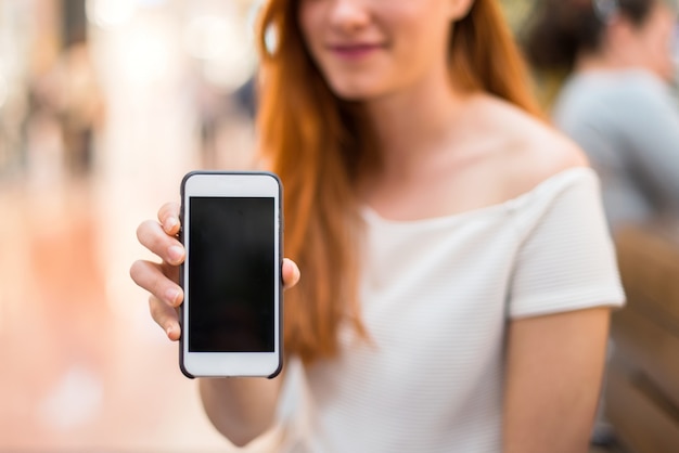Foto chica bonita joven pelirroja en un centro comercial manteniendo una conversación con el móvil