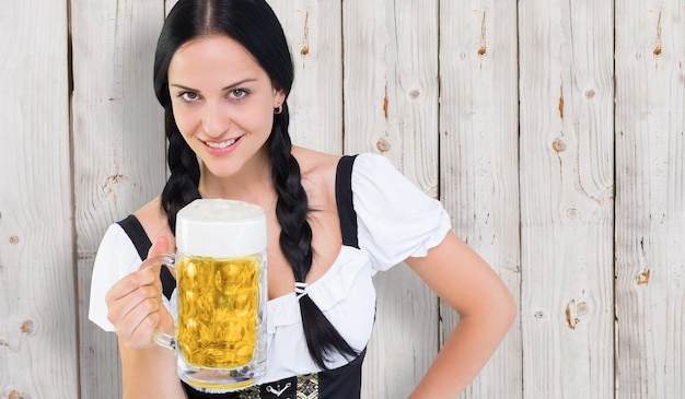 Foto chica bonita oktoberfest sosteniendo jarra de cerveza contra el fondo de madera