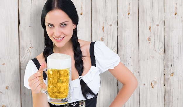 Chica bonita oktoberfest sosteniendo jarra de cerveza contra el fondo de madera