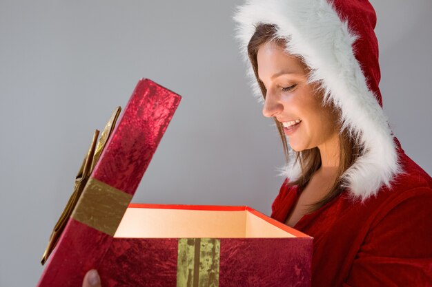 Chica bonita de santa abriendo un regalo