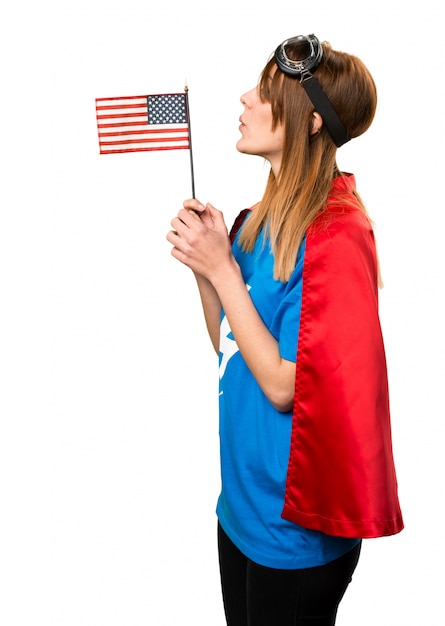 Chica bonita superhéroe sosteniendo una bandera americana