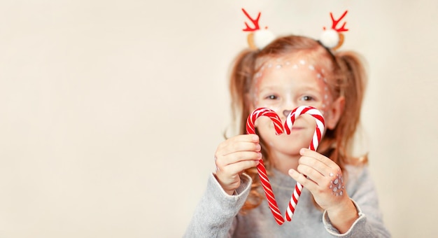 Foto chica borrosa en cuernos de navidad piruletas dobladas en forma de corazón