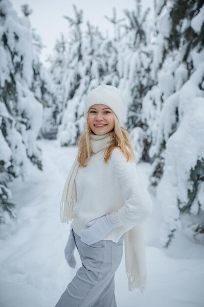 Una chica en un bosque de invierno, rubia, un divertido paseo por la naturaleza.