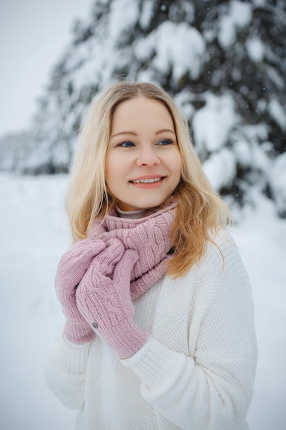 Una chica en un bosque de invierno, rubia, un divertido paseo por la naturaleza.