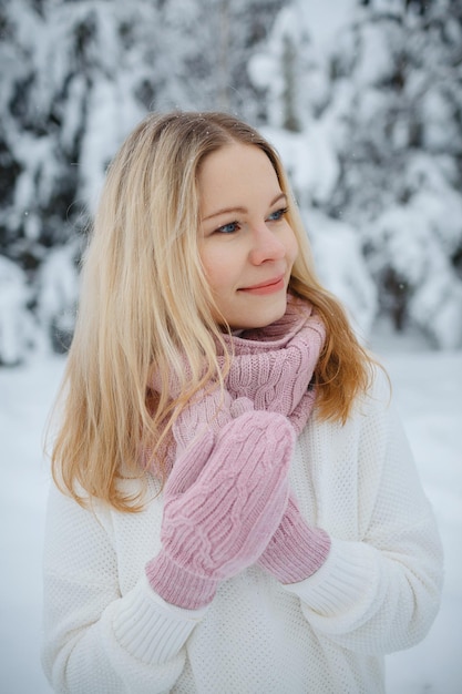 Una chica en un bosque de invierno, rubia, un divertido paseo por la naturaleza.