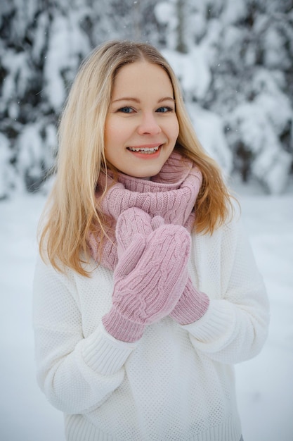 Una chica en un bosque de invierno, rubia, un divertido paseo por la naturaleza.