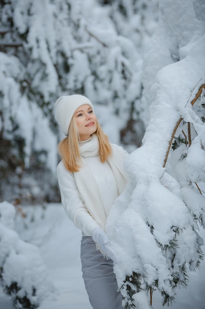 Una chica en un bosque de invierno, rubia, un divertido paseo por la naturaleza.