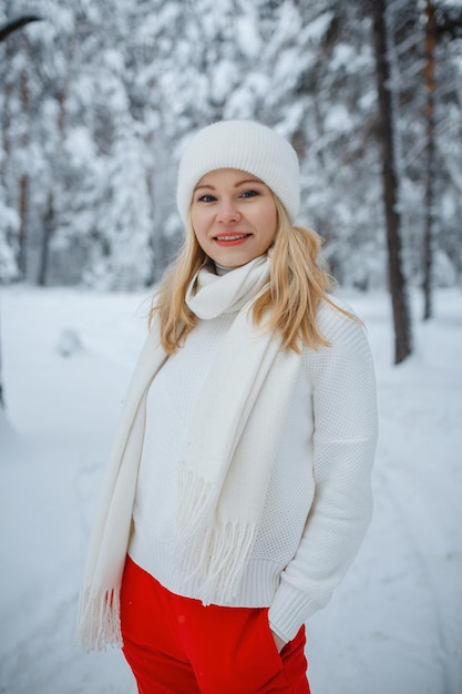 Una chica en un bosque de invierno, rubia, un divertido paseo por la naturaleza.