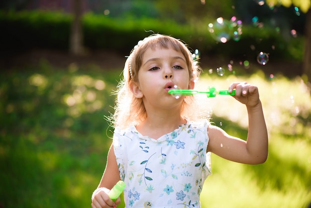Chica con burbujas en una tarde soleada de verano