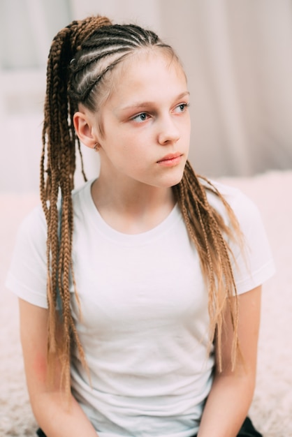 Chica con cabello castaño y coletas trenzadas con cabello artificial