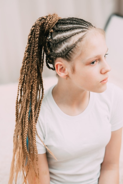 Chica con cabello castaño y coletas trenzadas con cabello artificial