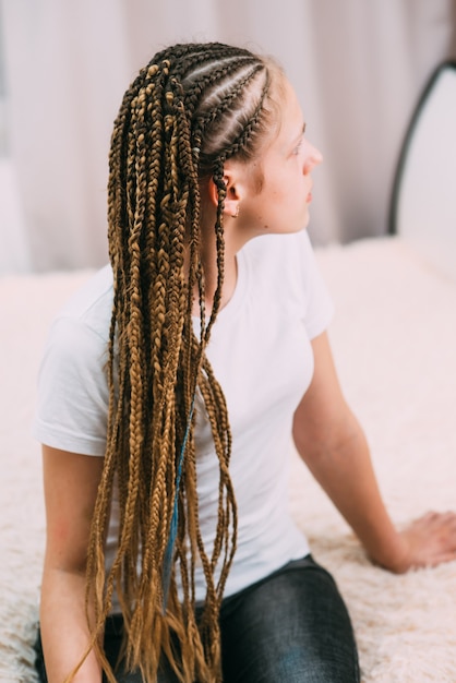 Chica con cabello castaño y coletas trenzadas con cabello artificial