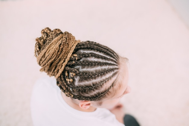 Chica con cabello castaño y coletas trenzadas con cabello artificial