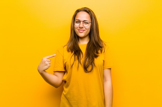 chica de cabello castaño sonriendo y apuntando a sí mismo