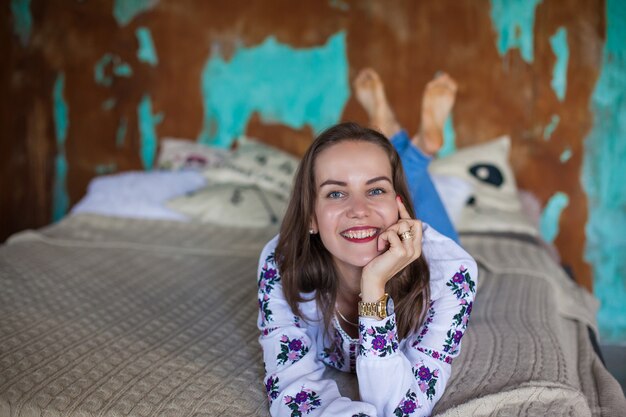 Chica con cabello castaño yace en la cama