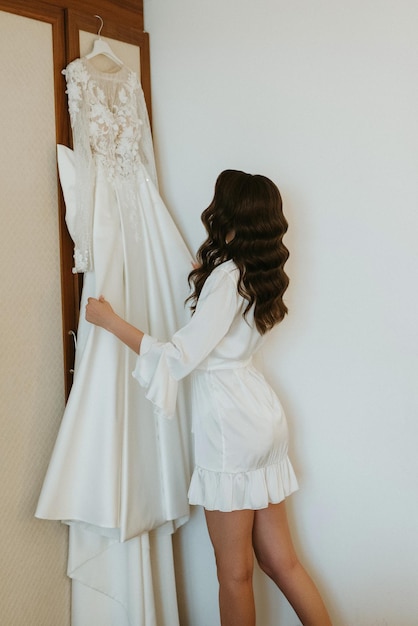 Foto una chica de cabello marrón se pone un vestido de novia