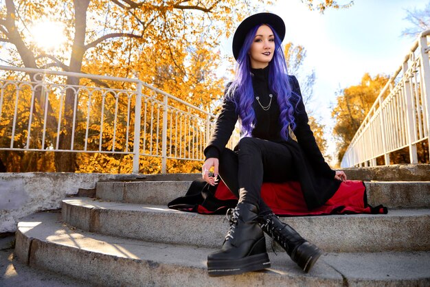 Chica con cabello morado en otoño en el parque