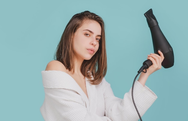 Foto chica con cabello rubio con secador de pelo, secado de peinado. peinado, concepto de peluquería.