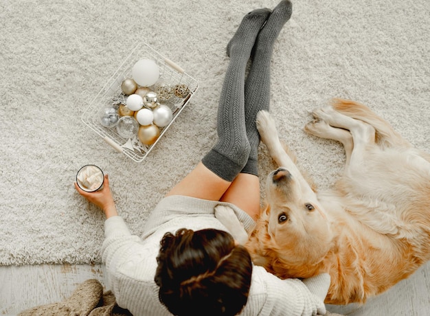 Chica con cacao y perro golden retriever