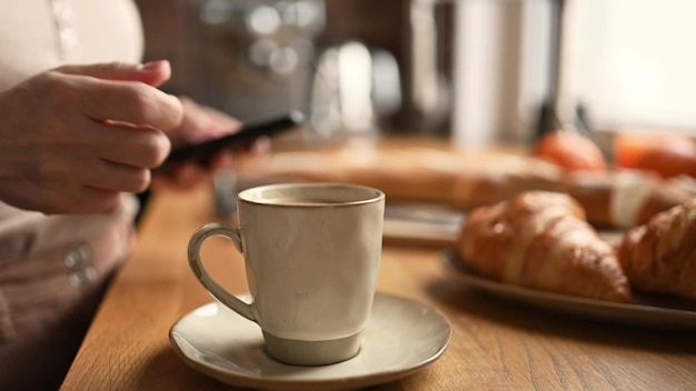 Chica con café capuchino y teléfono inteligente.