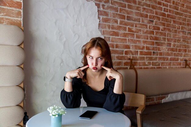 Foto la chica del café muestra una cara graciosa.