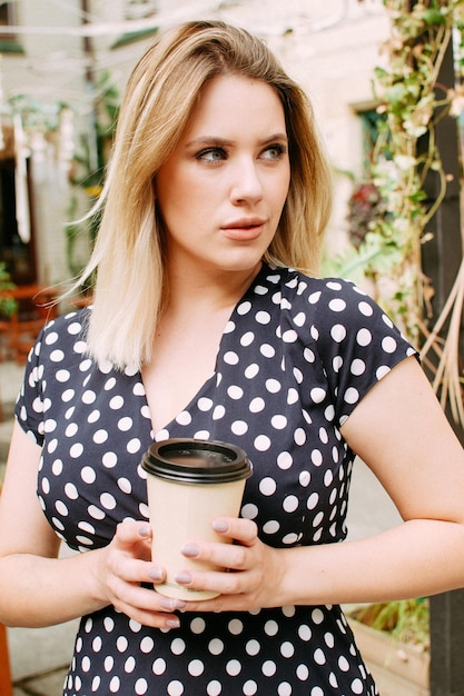 Chica en un café sosteniendo una taza de café