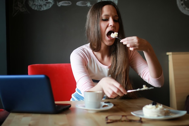 Chica en un café para tomar una taza de café con el portátil