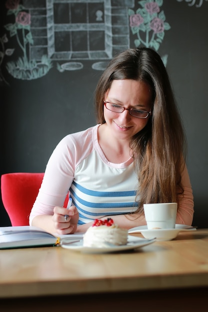 Chica en un café para tomar una taza de café con el portátil