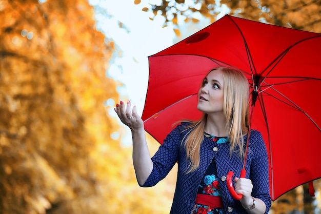 Chica de la calle con un paraguas a pasear en un día de otoño