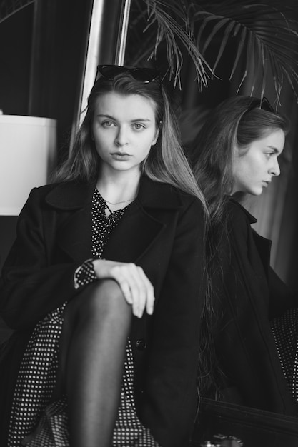 Chica con una cámara en un café, blanco y negro