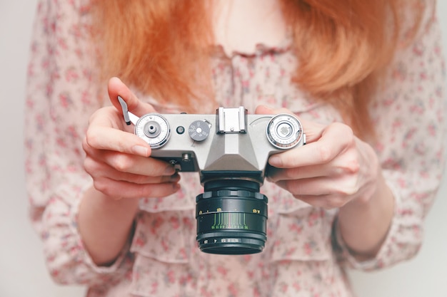 Chica con camara vintage en las manos.