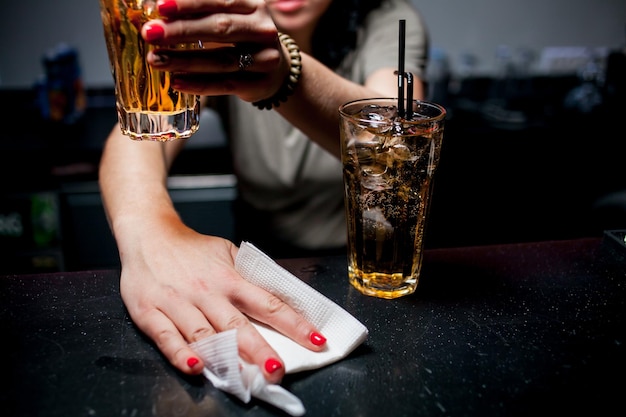 La chica camarera prepara un cóctel en la discoteca Camarera en el trabajo en un club