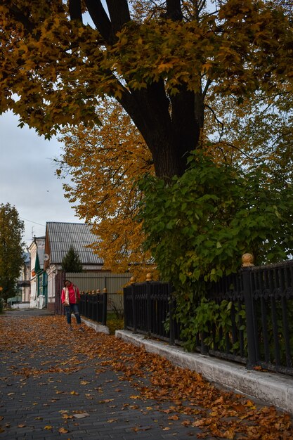 Chica camina por la ciudad en otoño