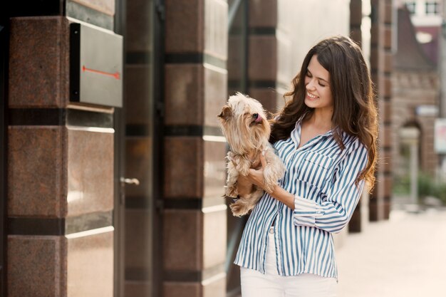 Chica camina con un perro en la calle de la ciudad.