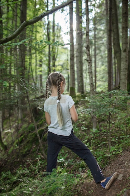 Chica caminando en el bosque solo turismo senderismo para explorar la naturaleza y ella misma bienestar y vida lenta