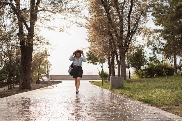 Chica caminando bajo la lluvia en un caluroso día de verano