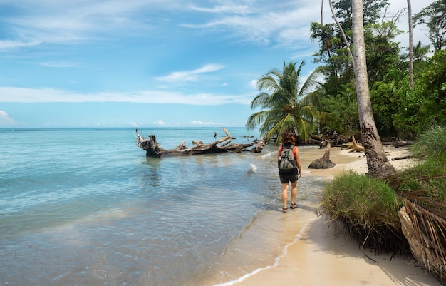 Chica caminando por la orilla de la playa