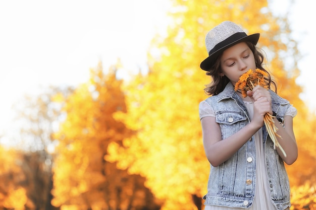 Chica caminando en el parque de otoño. Otoño en la ciudad, niña con papá a pasear. Los padres caminan con niños pequeños. Gente del parque de otoño