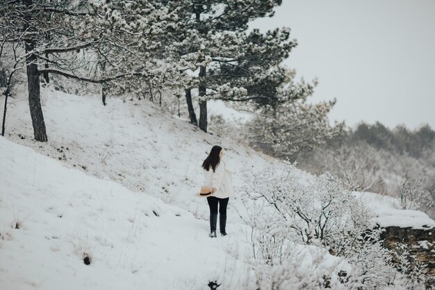 Chica caminando sobre una montaña nevada.