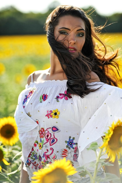 Chica en camisa al aire libre en medio de girasol